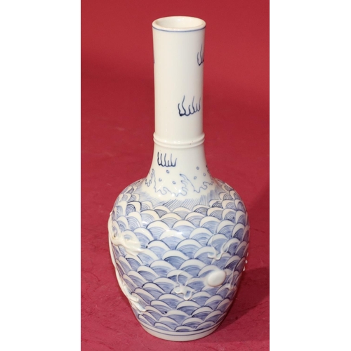 62 - An Oriental round bulbous thin necked vase on blue and white ground with raised dragon decoration, 2... 