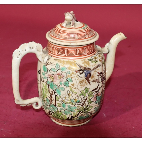 63 - An Oriental glazed earthenware teapot on white and red ground with bird, floral, leaf and key patter... 