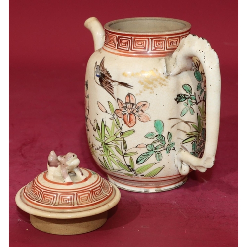 63 - An Oriental glazed earthenware teapot on white and red ground with bird, floral, leaf and key patter... 