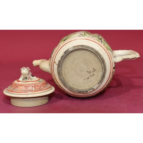 63 - An Oriental glazed earthenware teapot on white and red ground with bird, floral, leaf and key patter... 