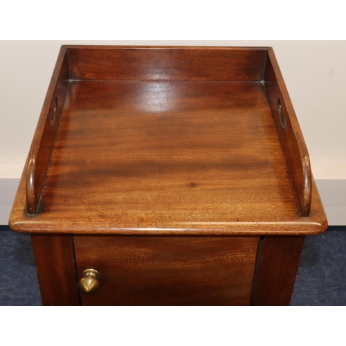 693 - A Victorian mahogany pot cupboard with galleried top, single panel door with knob handle, on round t... 