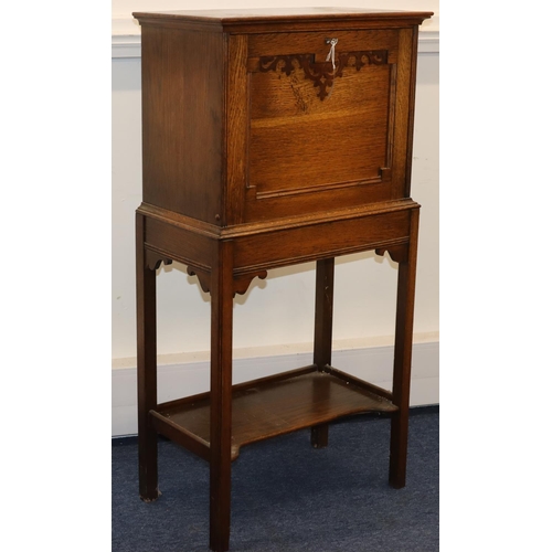 701 - An oak full front writing cabinet enclosing pigeonholes and drawers, on square legs with under tier,... 