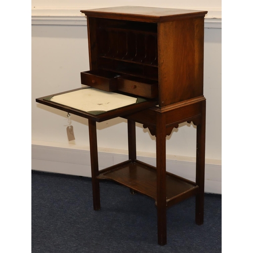 701 - An oak full front writing cabinet enclosing pigeonholes and drawers, on square legs with under tier,... 