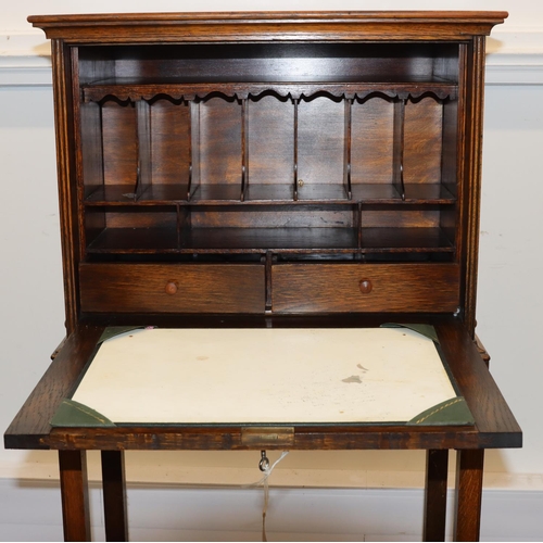 701 - An oak full front writing cabinet enclosing pigeonholes and drawers, on square legs with under tier,... 