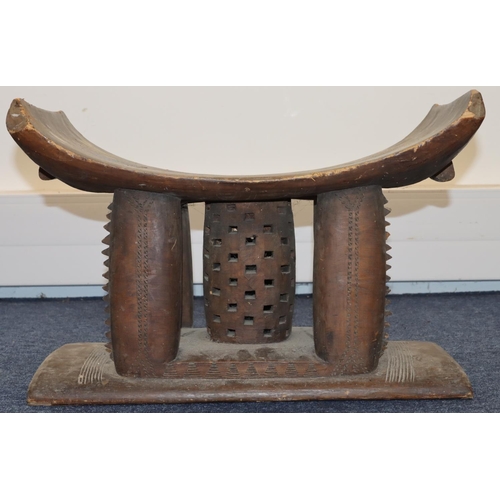 705 - An Ashanti stool with curved top, carved supports, on rectangular base, 56cm wide, 34cm deep, 37cm h... 