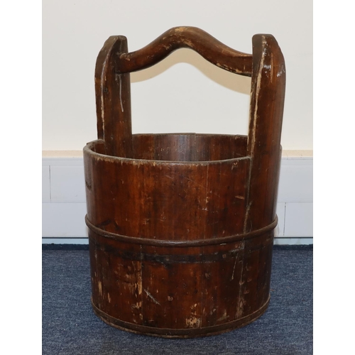 706 - A 19th Century Japanese fruitwood circular bucket with fixed overhead handle and part cast iron band... 