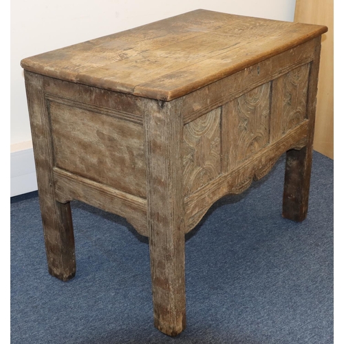 707 - An 18th Century small oak coffer with triple panelled carved front, on stile feet, hinged (inner bot... 