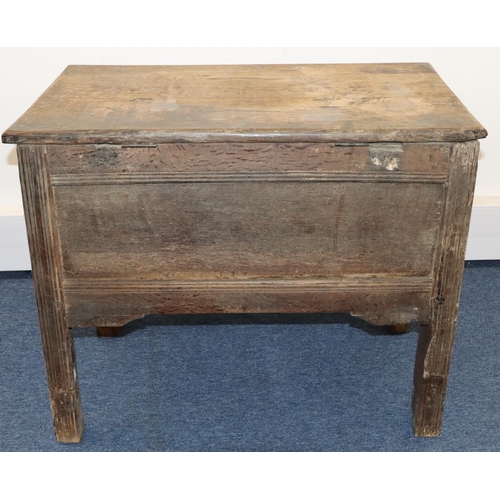 707 - An 18th Century small oak coffer with triple panelled carved front, on stile feet, hinged (inner bot... 