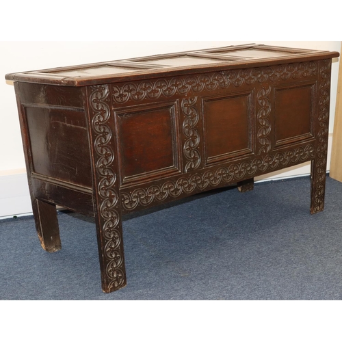 709 - An 18th Century oak coffer with triple panelled front and carved leaf and scroll decoration, triple ... 