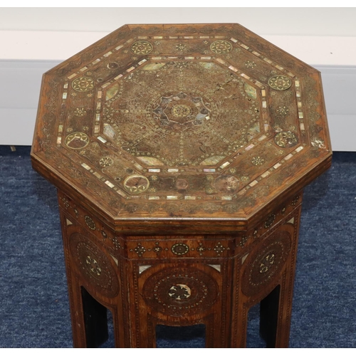 714 - An Eastern octagonal shaped coffee table with allover inlaid brass, Mother of Pearl and boxing decor... 