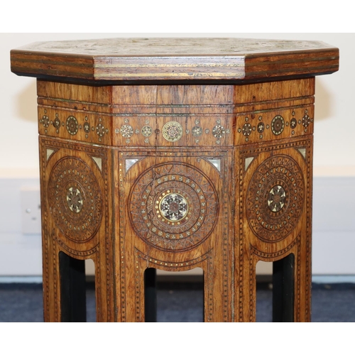 714 - An Eastern octagonal shaped coffee table with allover inlaid brass, Mother of Pearl and boxing decor... 