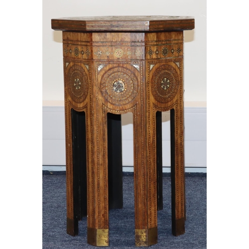 714 - An Eastern octagonal shaped coffee table with allover inlaid brass, Mother of Pearl and boxing decor... 