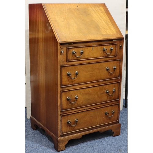 717 - A reproduction mahogany bureau with fall front, 4 long graduated drawers below with drop handles on ... 