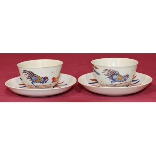 84 - A pair of 18th Century tea bowls and saucers on white, blue and red ground with fighting cockerels (... 