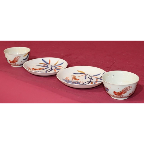 84 - A pair of 18th Century tea bowls and saucers on white, blue and red ground with fighting cockerels (... 