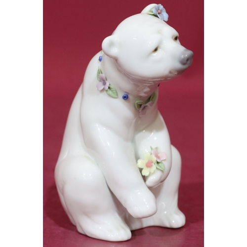 91 - A Lladro figure of a seated polar bear with encrusted floral decoration to neck, 12.5cm high