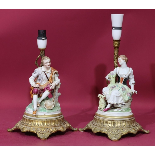 96 - A pair of Continental china and gilt metal table lamps in the form of a seated gentleman and lady, o... 