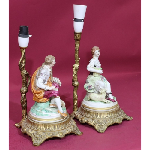 96 - A pair of Continental china and gilt metal table lamps in the form of a seated gentleman and lady, o... 