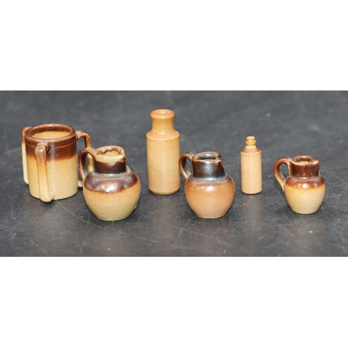 98 - 3 Miniature graduated Royal Doulton earthenware round bulbous shaped jugs, largest 2.5cm high, a sim... 