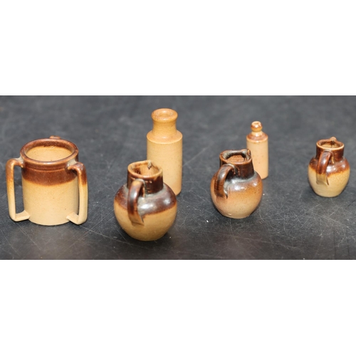 98 - 3 Miniature graduated Royal Doulton earthenware round bulbous shaped jugs, largest 2.5cm high, a sim... 