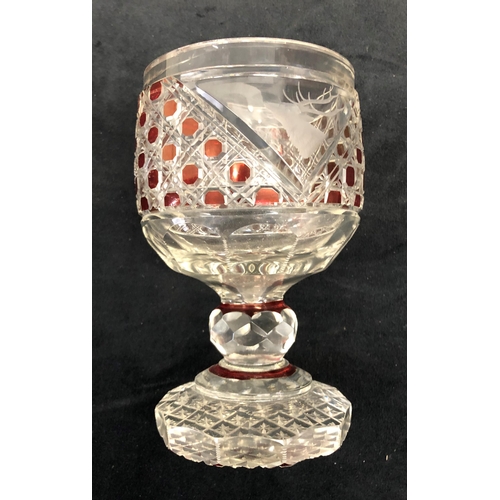 3299 - A ruby and clear cut glass round trumpet shaped tumbler with engraved stags head motif on bulbous st... 