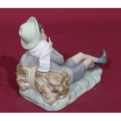 57 - A Lladro figure of a relaxing young boy, 21cm long