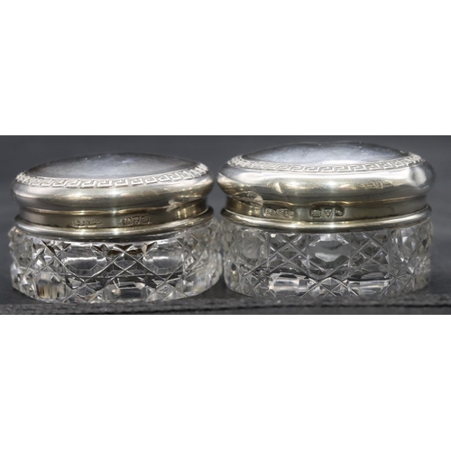 267 - 2 cut glass round small dressing table pots with Chester silver tops