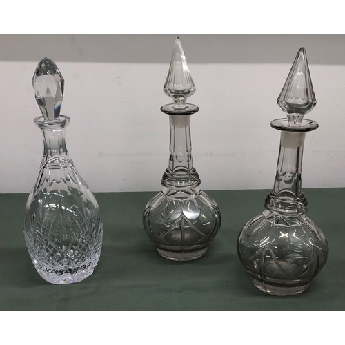 4058 - A pair of glass decanters, 34.5cm high overall (chips to tip of both stoppers) and 1 other decanter,... 