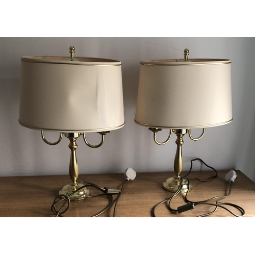 4103 - A pair of gold coloured table lamps each with 2 candle style bulbs, John Lewis stamp to base, cream/... 