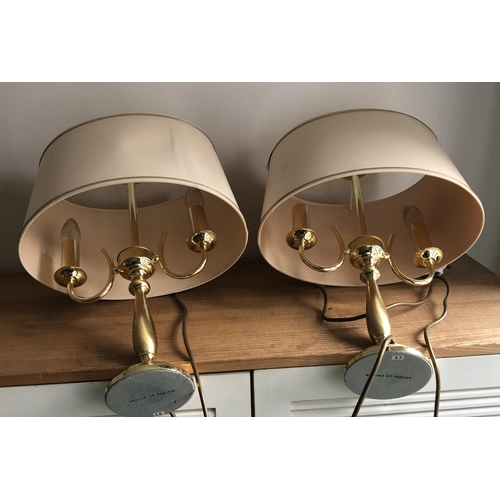 4103 - A pair of gold coloured table lamps each with 2 candle style bulbs, John Lewis stamp to base, cream/... 