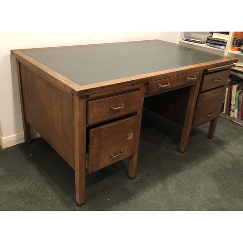 4107 - An oak desk with 3 upper drawers, brass handles, 2 lower filing drawers and 2 pull-out shelves, gree... 