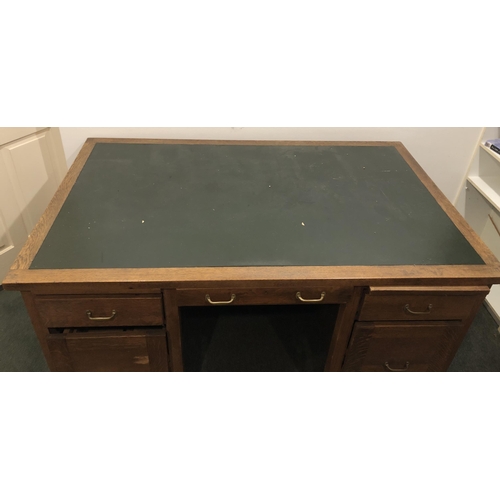 4107 - An oak desk with 3 upper drawers, brass handles, 2 lower filing drawers and 2 pull-out shelves, gree... 