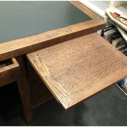 4107 - An oak desk with 3 upper drawers, brass handles, 2 lower filing drawers and 2 pull-out shelves, gree... 