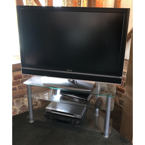 4108 - A large Sony flat screen TVA glass and chrome/metal TV stand, with 2 glass shelves and including , 1... 