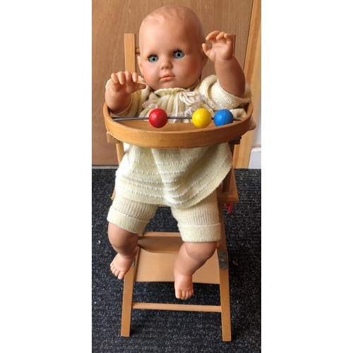 4011 - A wood toy highchair folding down to chair and table, 63cm high overall and a baby doll, 50cm long, ... 