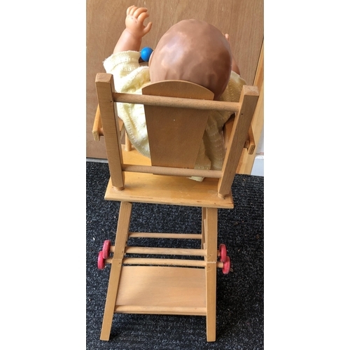 4011 - A wood toy highchair folding down to chair and table, 63cm high overall and a baby doll, 50cm long, ... 