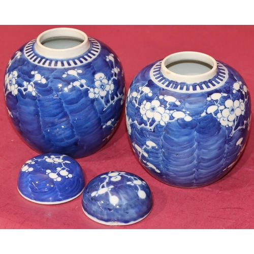 104 - A pair of Oriental round bulbous lidded ginger jars on blue and white ground with branch and blossom... 