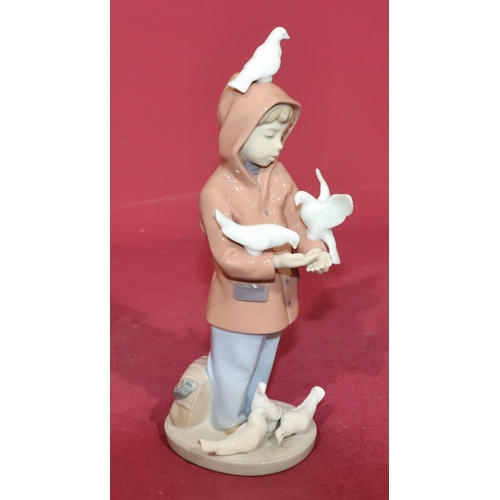 132 - A Lladro figure of a young boy holding doves, 24cm high.