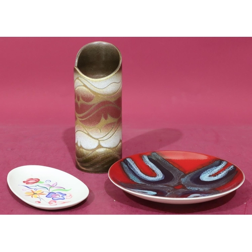 20 - A Poole cylindrical vase on brown, red and white ground, 22cm high, a Poole round dish on vibrant re... 