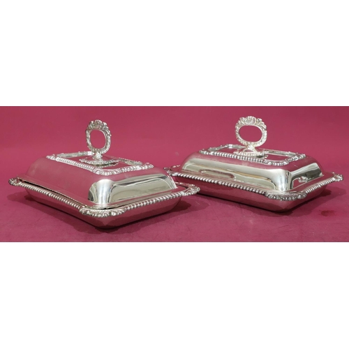 218 - A pair of silver plated rectangular entrée dishes with cover and raised shell, leaf and gadroon rims... 