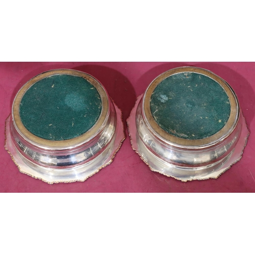 219 - A pair of silver plated round bulbous shaped wine coasters with raised shell, leaf and scroll rims a... 