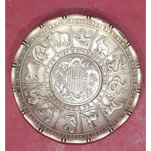 222 - An Oriental silvered circular dish with raised zodiac figures of animals, 10cm diameter