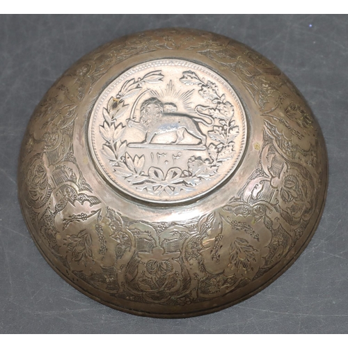 239 - An Eastern silver coloured metal small round bowl inset with a coin and allover engraved floral and ... 