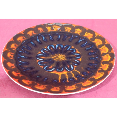 24 - A Poole round charger on vibrant black, blue, orange and red ground, 36.5cm diameter