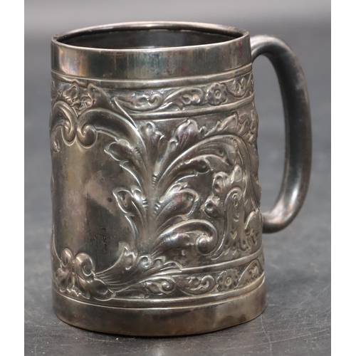 242 - A silver coloured metal christening mug with allover embossed leaf and scroll decoration, 7.2cm high... 