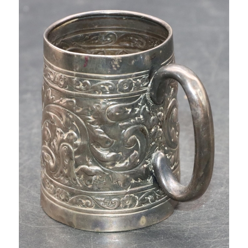 242 - A silver coloured metal christening mug with allover embossed leaf and scroll decoration, 7.2cm high... 