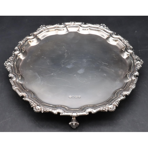 252 - An Elizabeth II silver pie crust card tray with raised shell and scroll rim on 3 splayed scroll feet... 