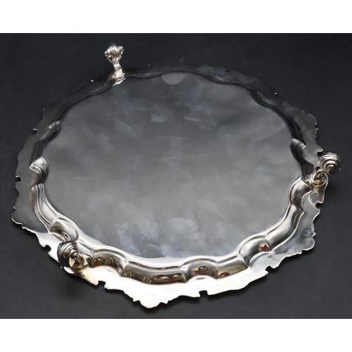 252 - An Elizabeth II silver pie crust card tray with raised shell and scroll rim on 3 splayed scroll feet... 