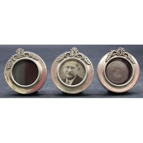 257 - A set of 3 925 small silver circular freestanding photograph frames with raised scroll tops, 5.6cm w... 