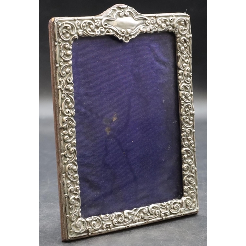 260 - A silver mounted freestanding photograph frame with allover embossed floral, leaf and scroll decorat... 